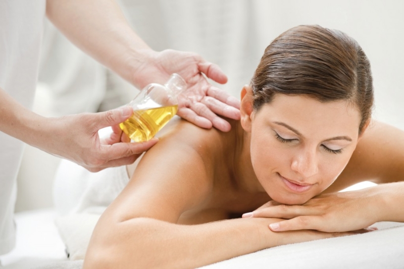 Aromatherapy oil massage with flowers and candles.